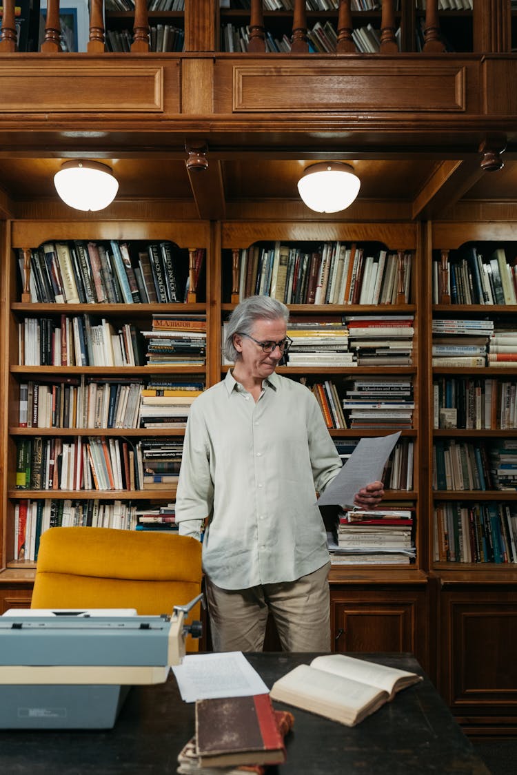 An Elderly Man Reading A Document