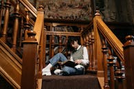 A College Student Reading a Book white Sitting on the Stairs