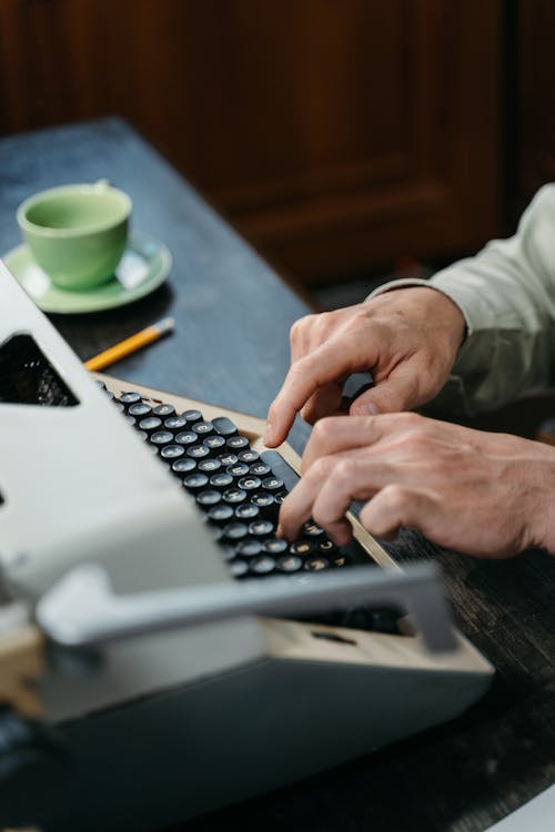 A Person Typing on Vintage Typewriter