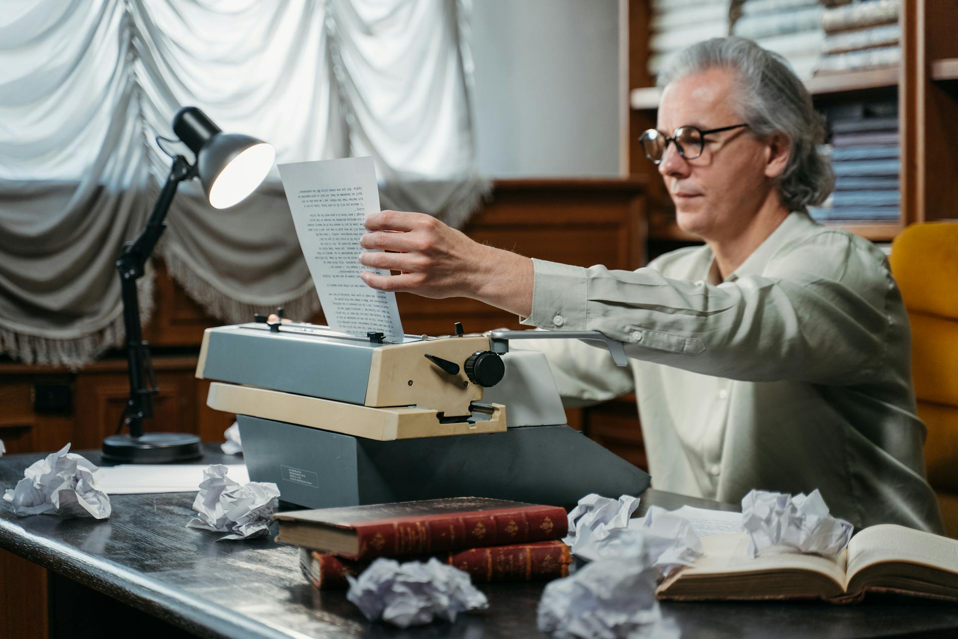 A Man Removing a Paper on a Vintage Typewriter