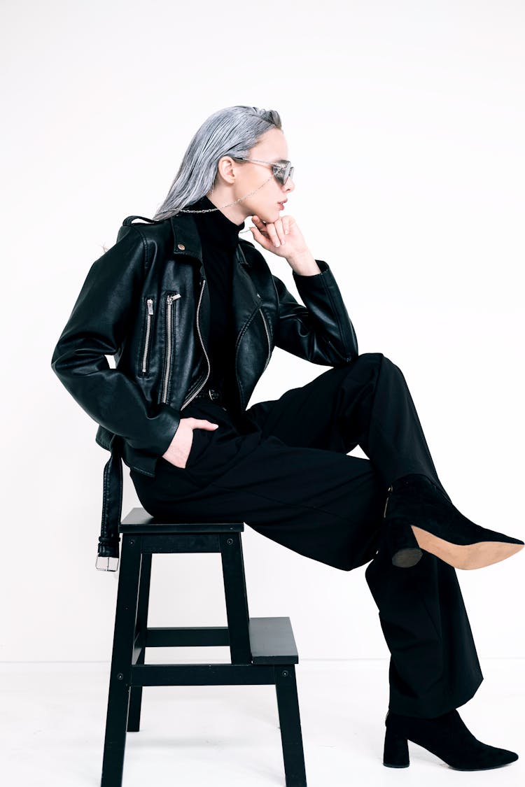 A Woman With Gray Hair Sitting On A Stool