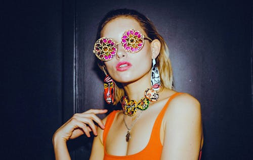 A Woman in an Orange Tank Top and Stylish Sunglasses