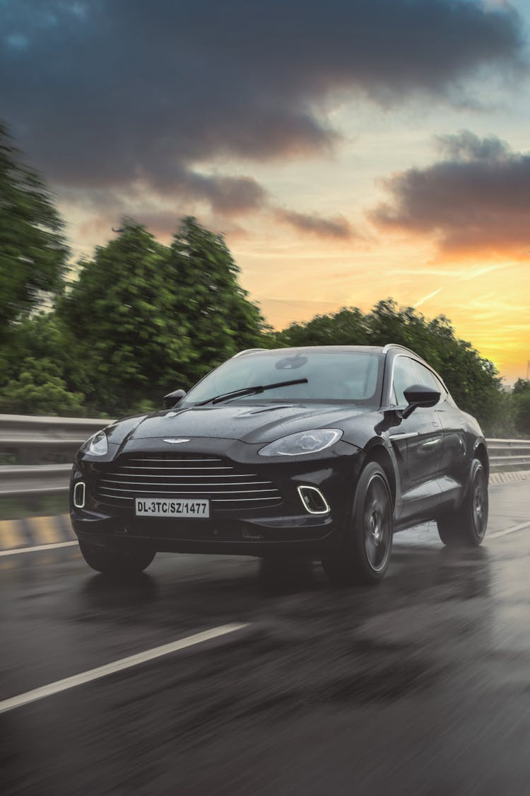 Black Aston Martin On Road During Sunset