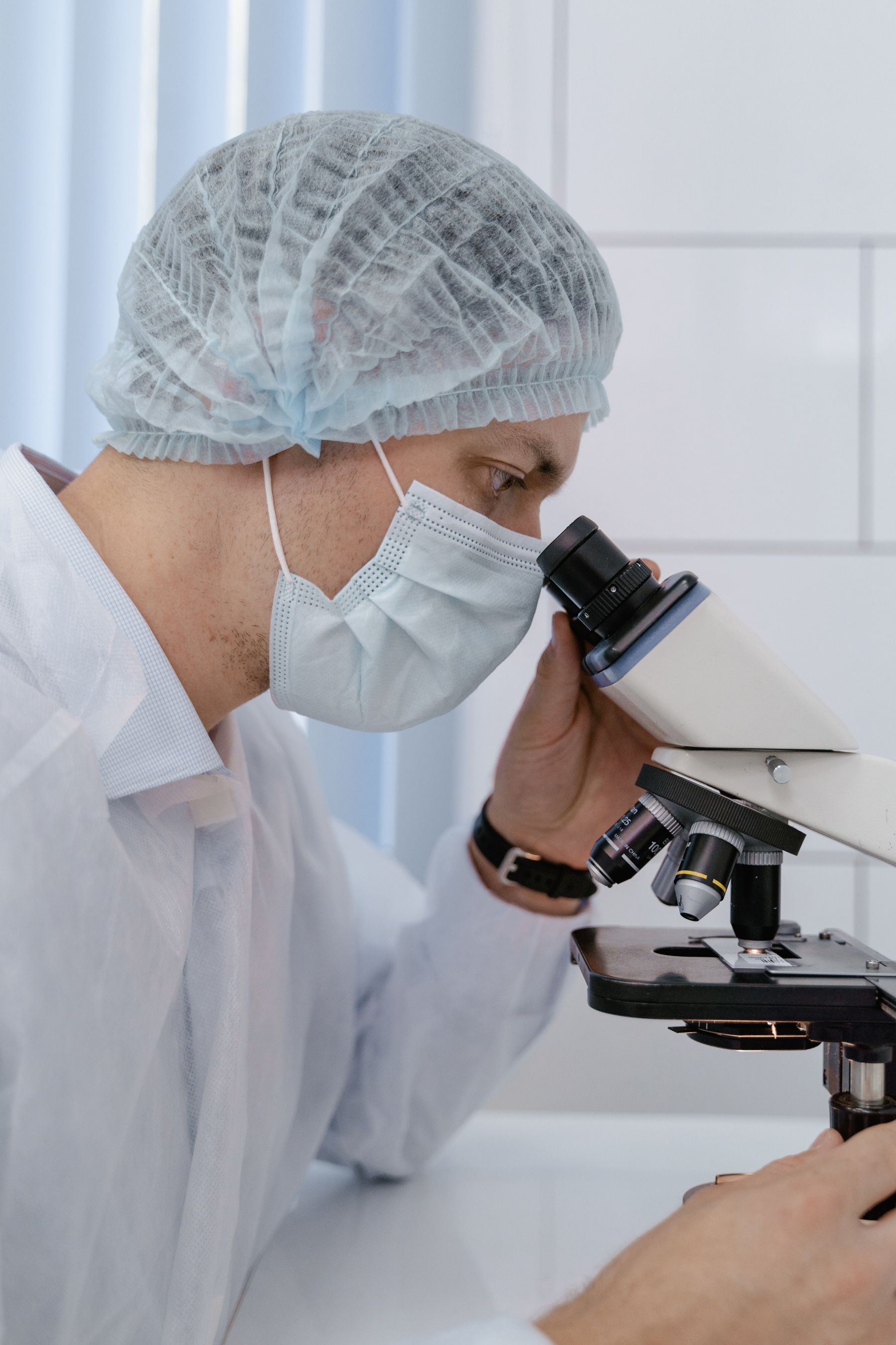 Scientist in laboratory gear examining a sample