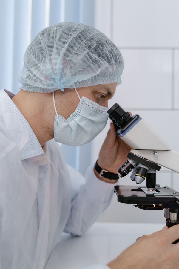 Scientist examining a sample under a microscope
