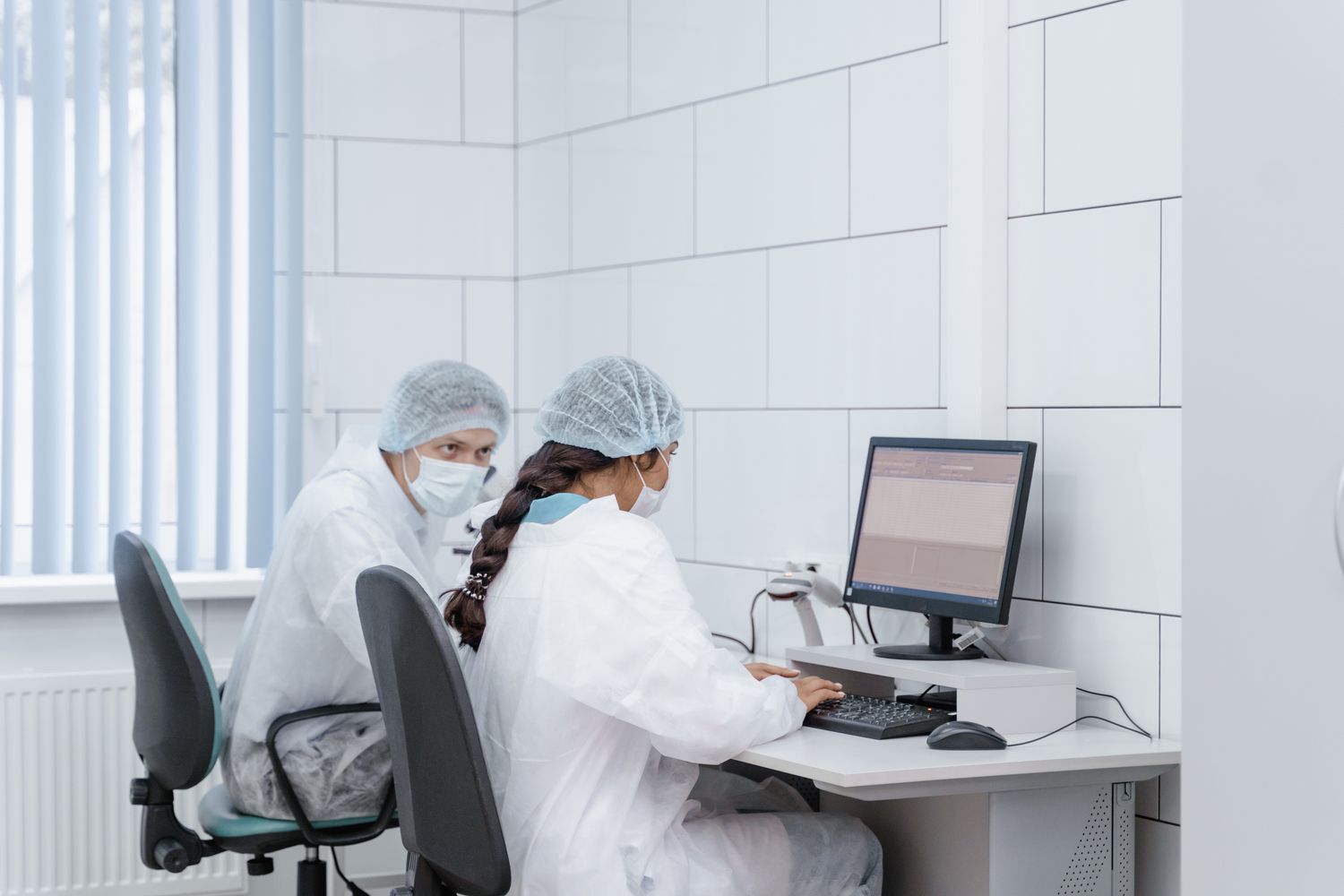 Two biomedical researchers reviewing scientific data together in a laboratory
