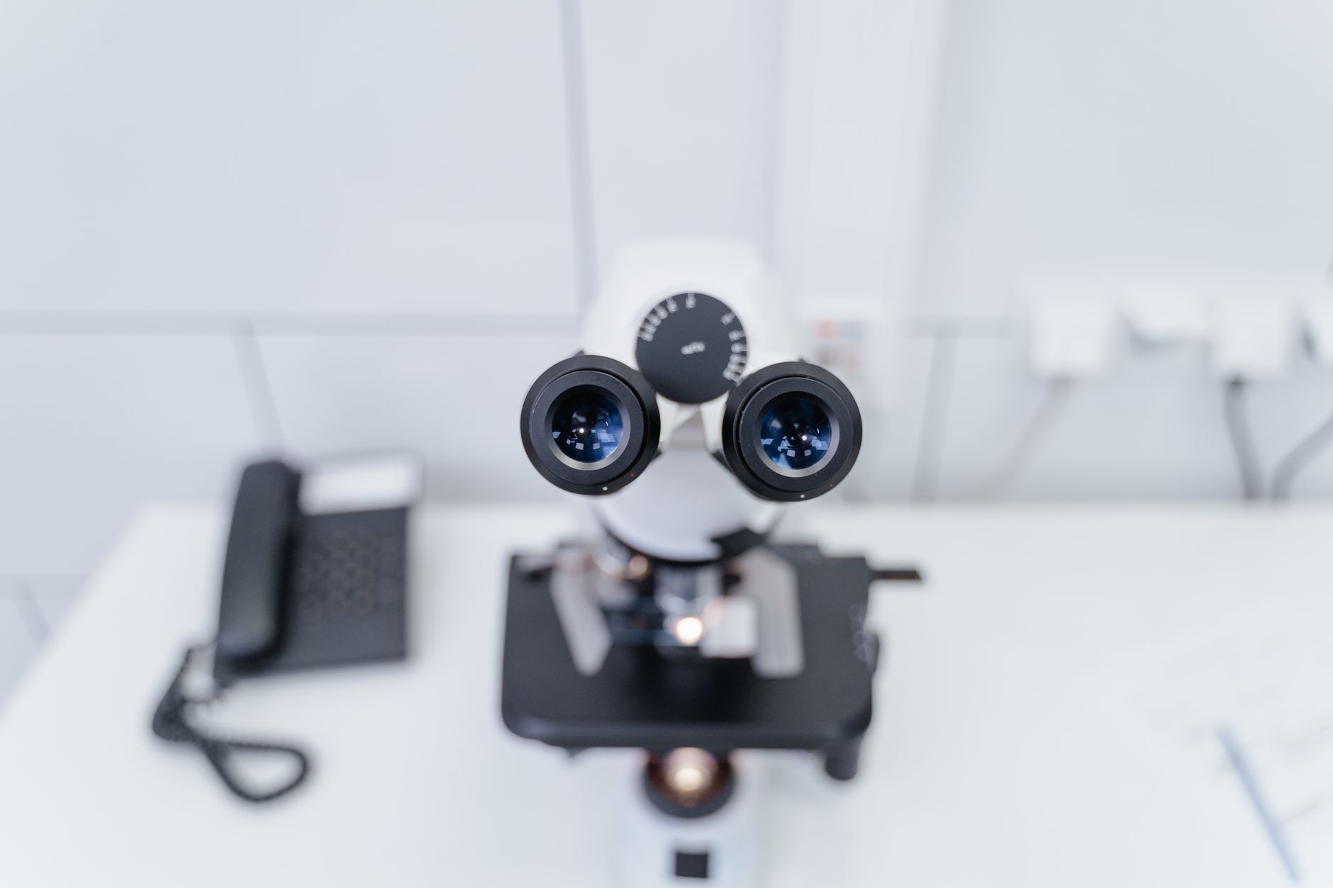 Close-up of a modern microscope in a laboratory setting, showcasing optics and technology.