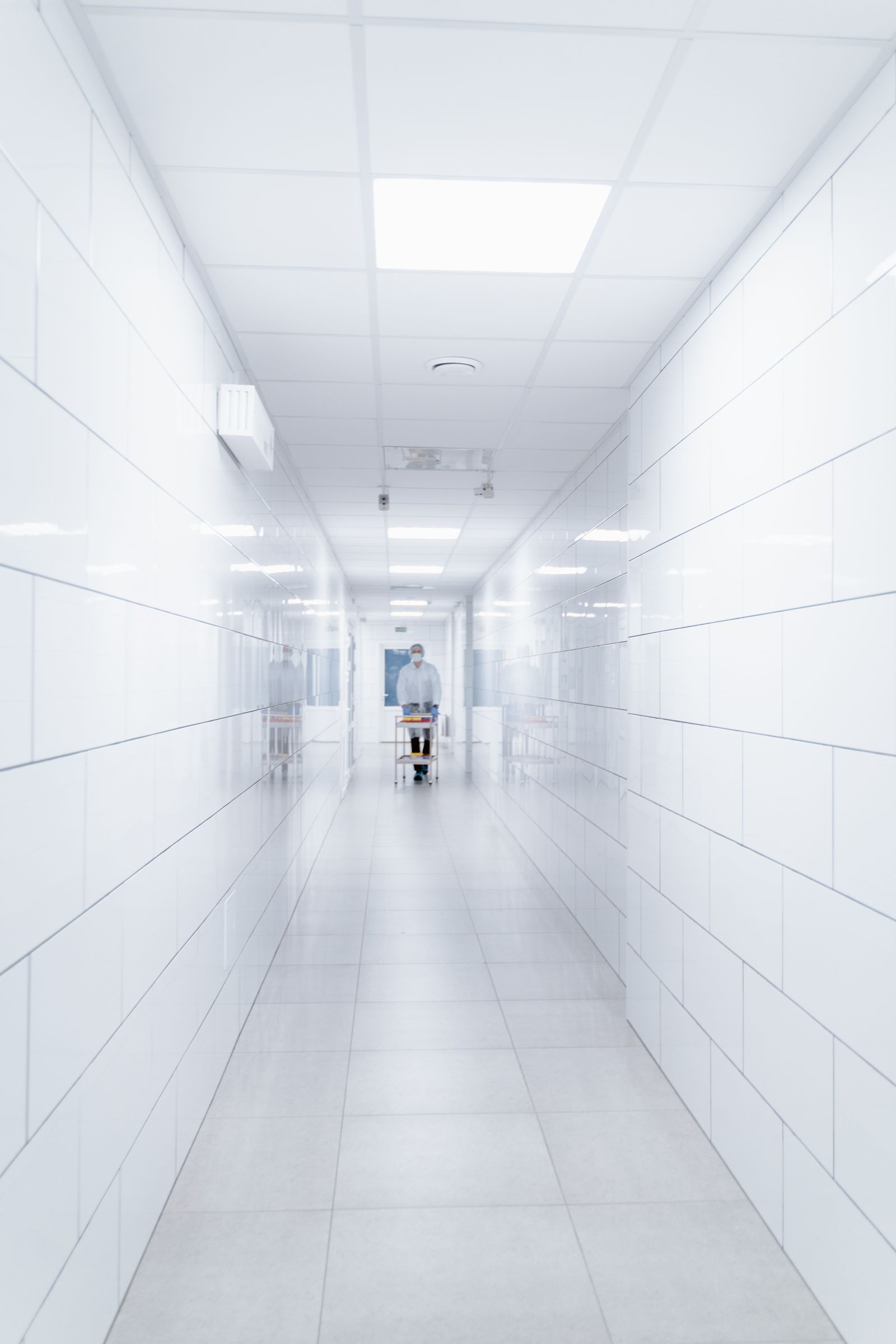 Clean modern hospital corridor with a medical professional walking