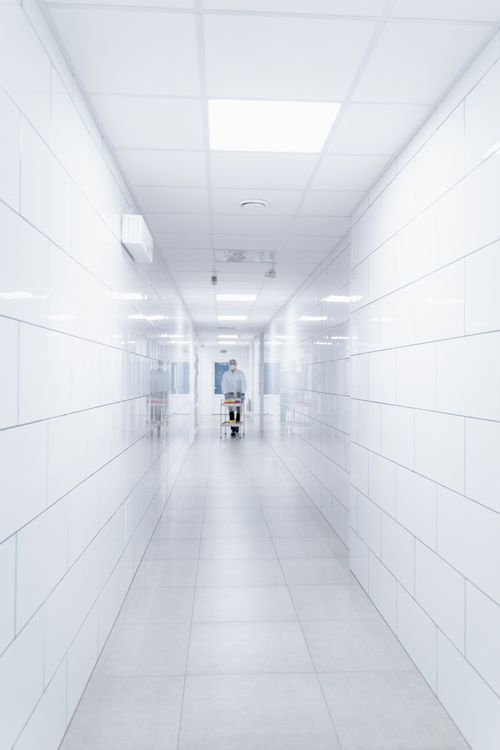 Free Clean and sterile hospital hallway with a single medical professional in view. Stock Photo