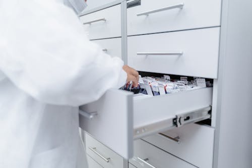 Person in Lab Coat looking through Files 