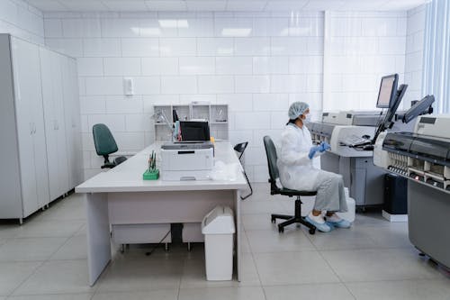 A Woman in White Lab Gown Looking at the Screen