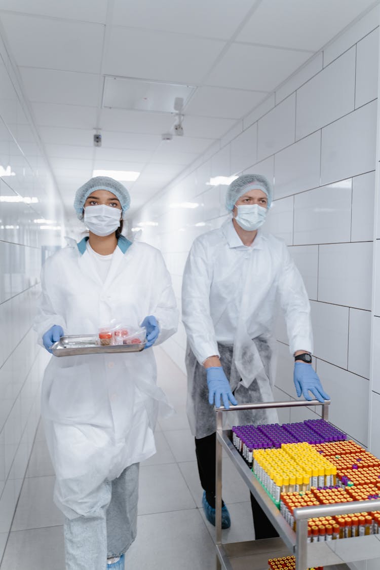 People Walking At The Hallway While Wearing Lab Gown And Face Mask