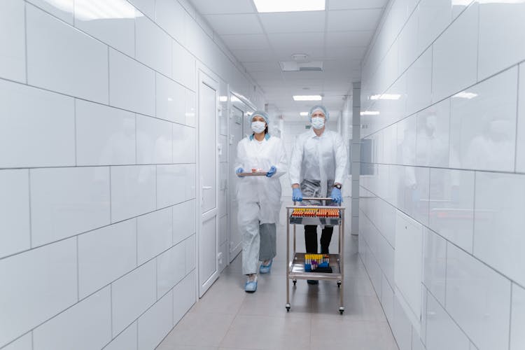 People Walking At The Hallway While Carrying Medical Supplies