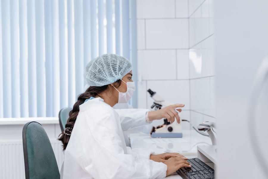 Medical professional working at a computer in a regulated environment