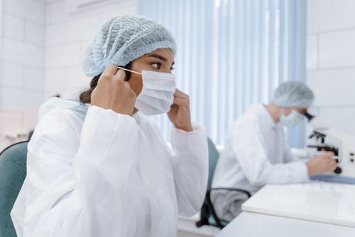 Free Two scientists in protective gear work diligently in a modern laboratory. Stock Photo