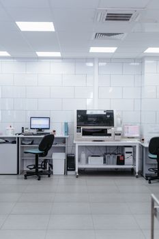 Spacious modern laboratory with computers and office chairs under bright lighting.