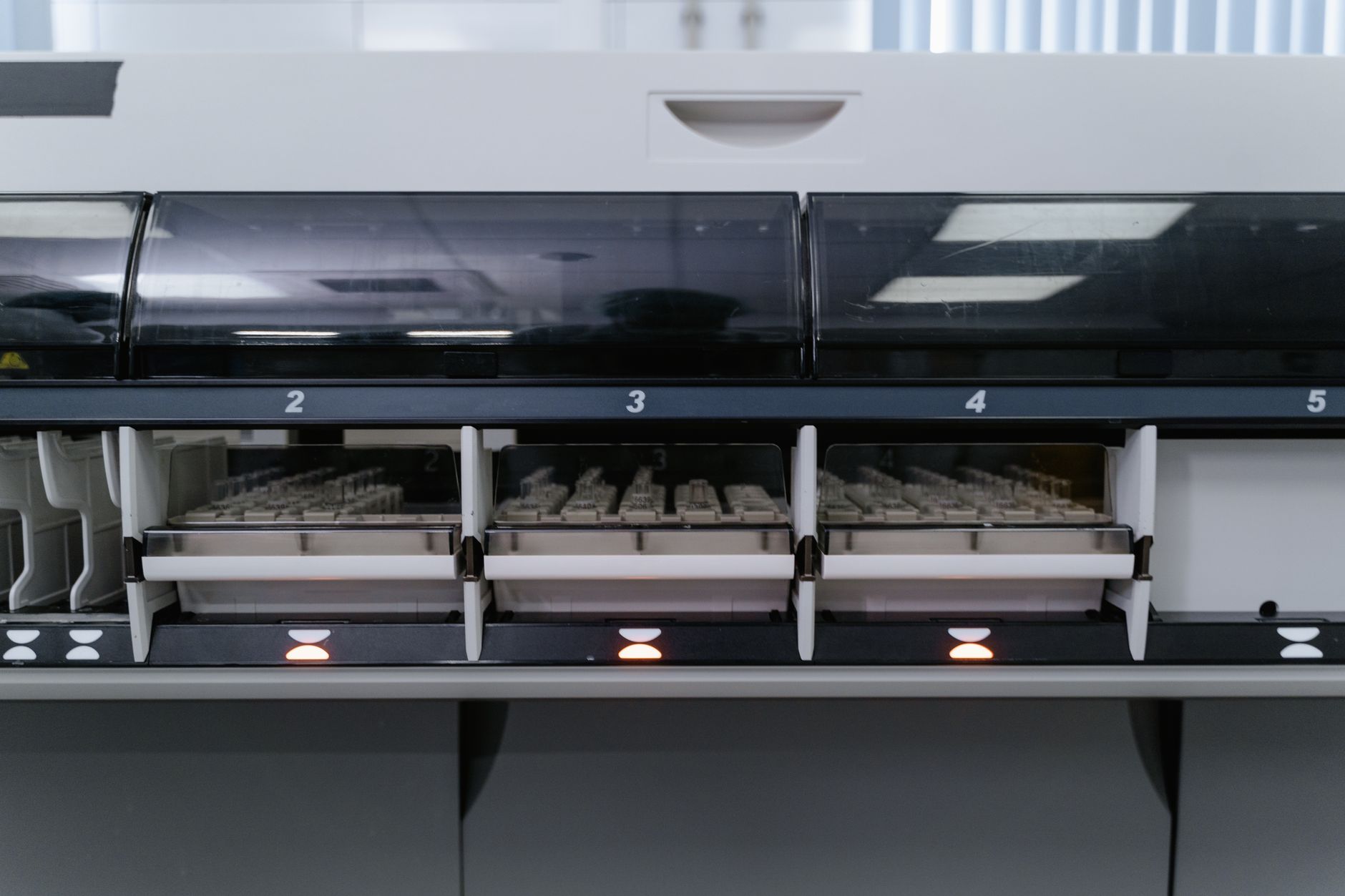Automated laboratory machine analyzing multiple test samples in healthcare research facility.