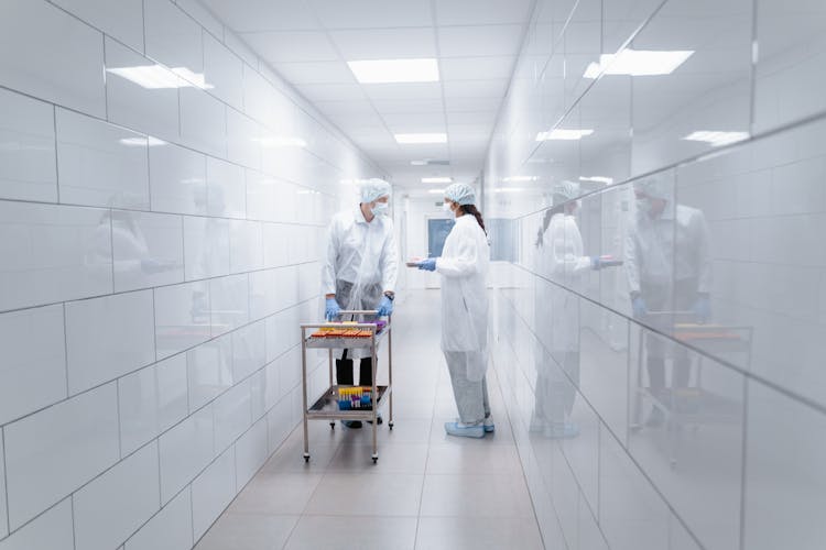 Two People In Protective Suits Talking In The Corridor