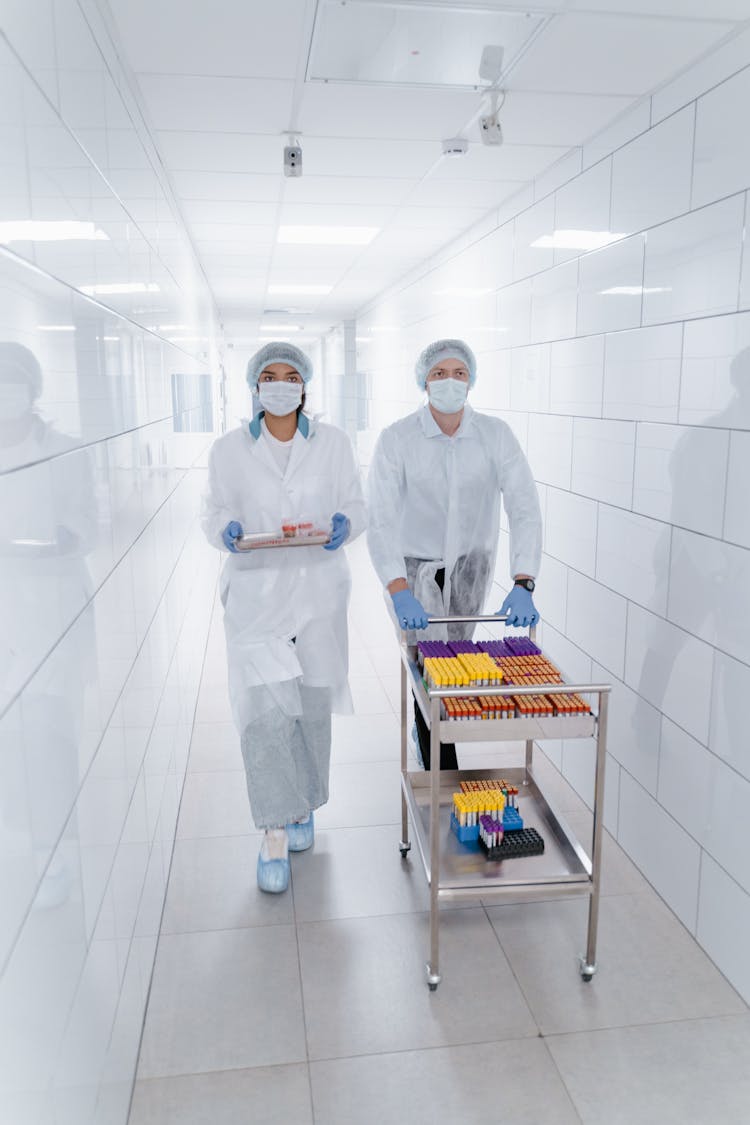 People Walking At The Hallway While Carrying Medical Supplies