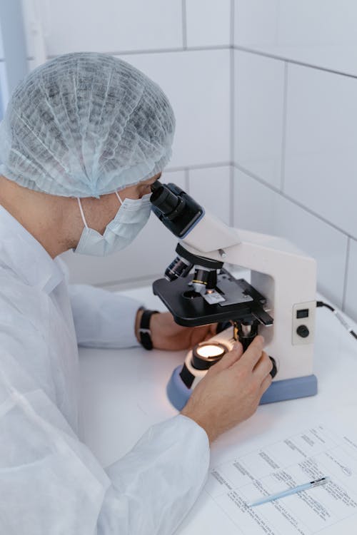 A High Angle Shot of a Man Looking at the Microscope