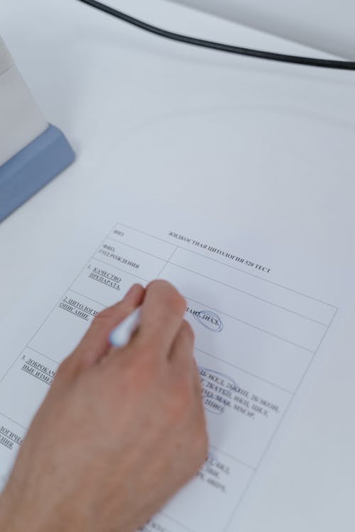 Person Writing on a Document 