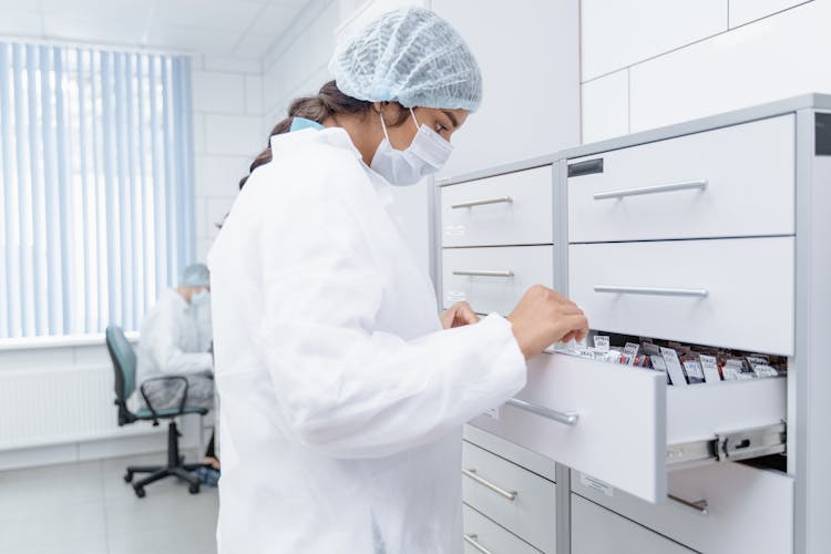 Medical Professional Looking At Archives On A Drawer 