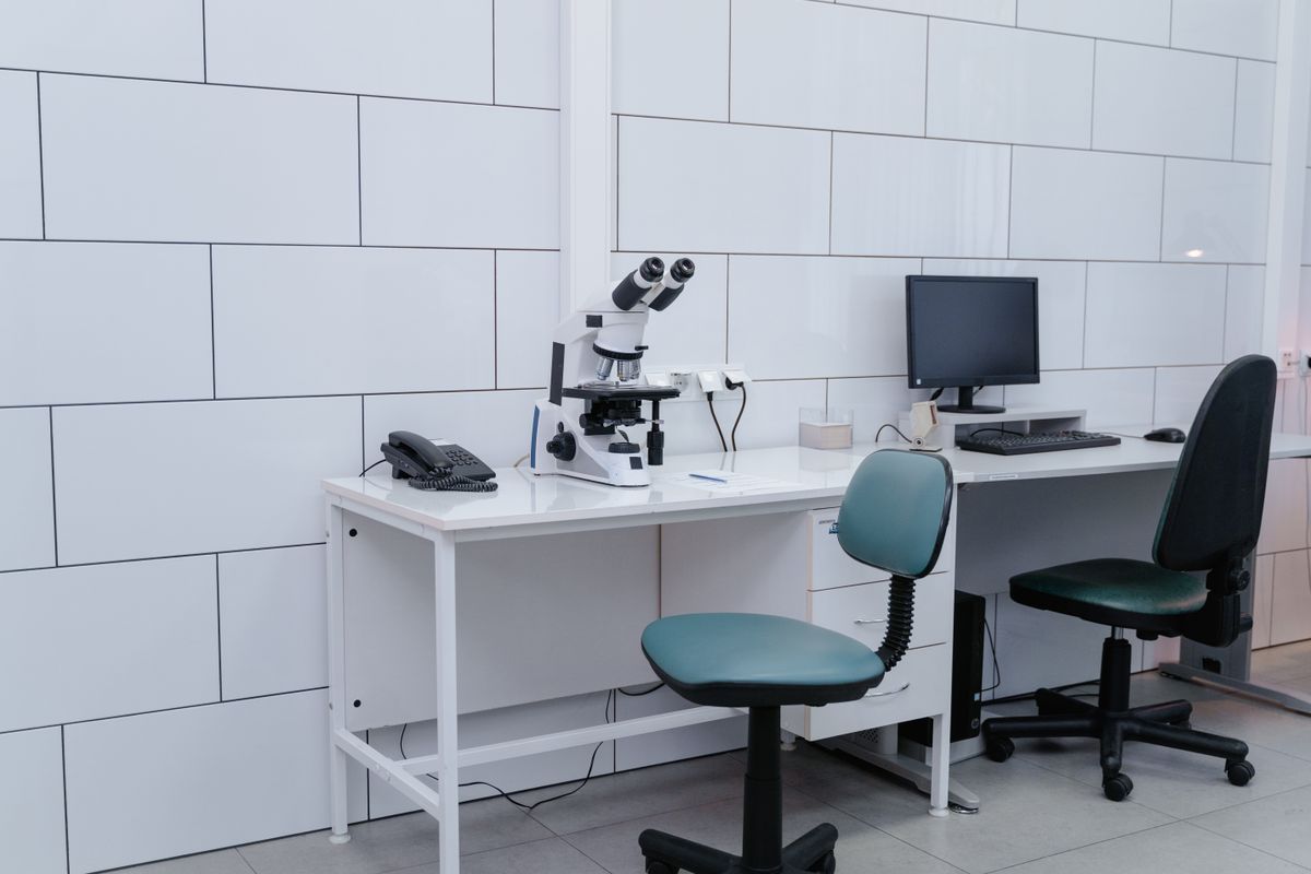 Modern laboratory with microscope, monitor, and office equipment on desk. Illustrative editorial photograph.