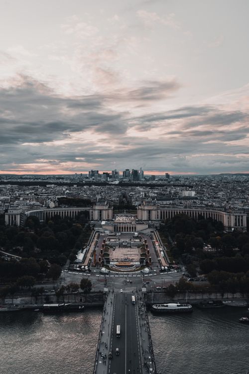 Free Stunning aerial shot of Paris featuring iconic landmarks and skyline under a dramatic sunset. Stock Photo