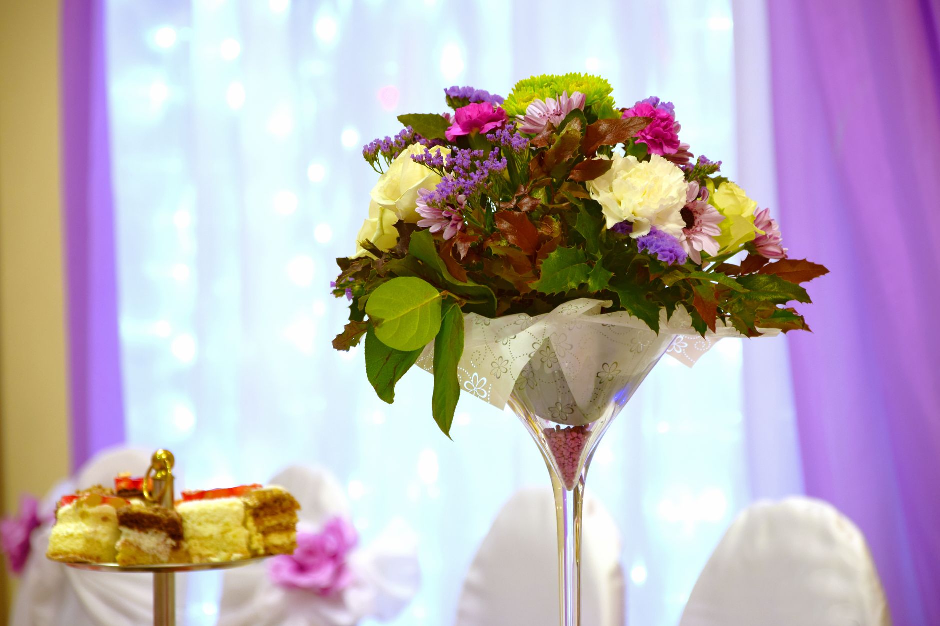 Menjaga Kualitas Standar Pelayanan dan Rasa Sajian Prasmanan Jagarasa untuk Setiap Acara 4 Beautiful floral centerpiece and cakes at an elegant wedding reception setting.