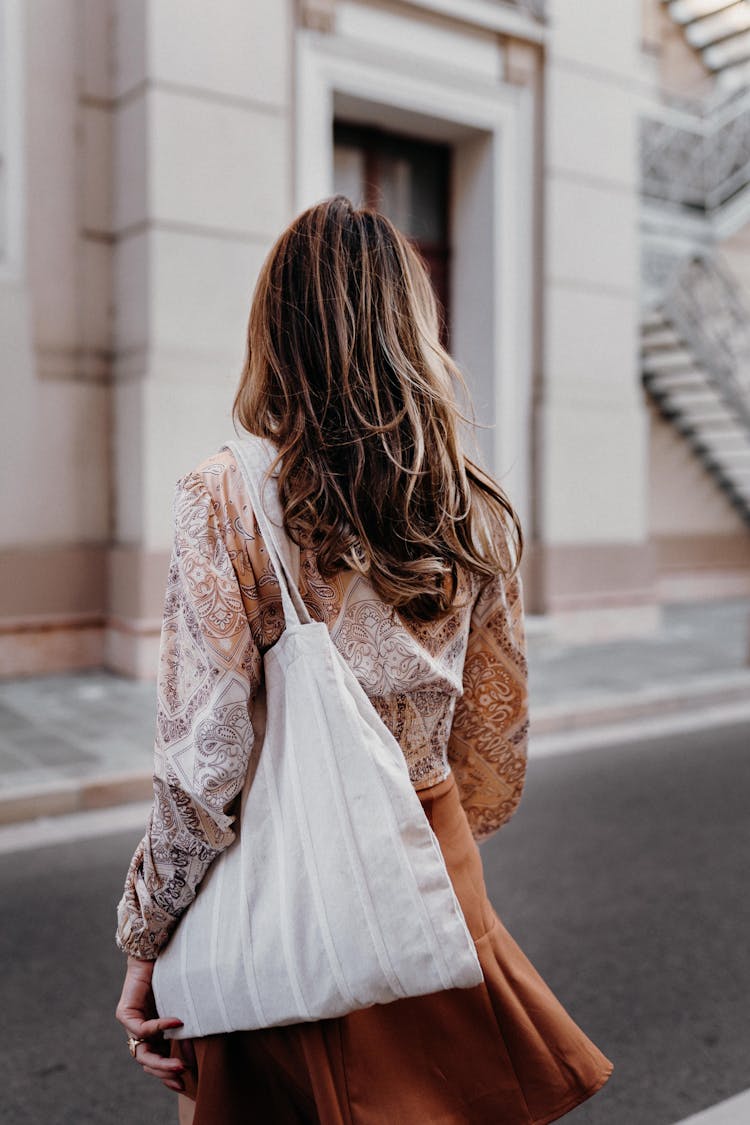 A Woman With A Tote Bag On Her Shoulder