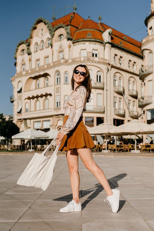 Free A Woman in Sunglasses Posing while Carrying a Tote Bag Stock Photo
