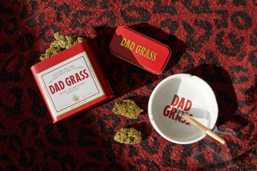 Cannabis products and accessories arranged on a vibrant carpet surface.