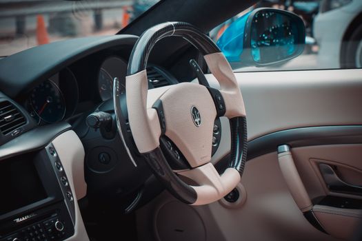 Close-up view of a luxurious Maserati car interior focusing on the elegant steering wheel design.