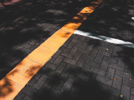 城市环境中，砖砌人行道上有着明显的黄线和阴影图案