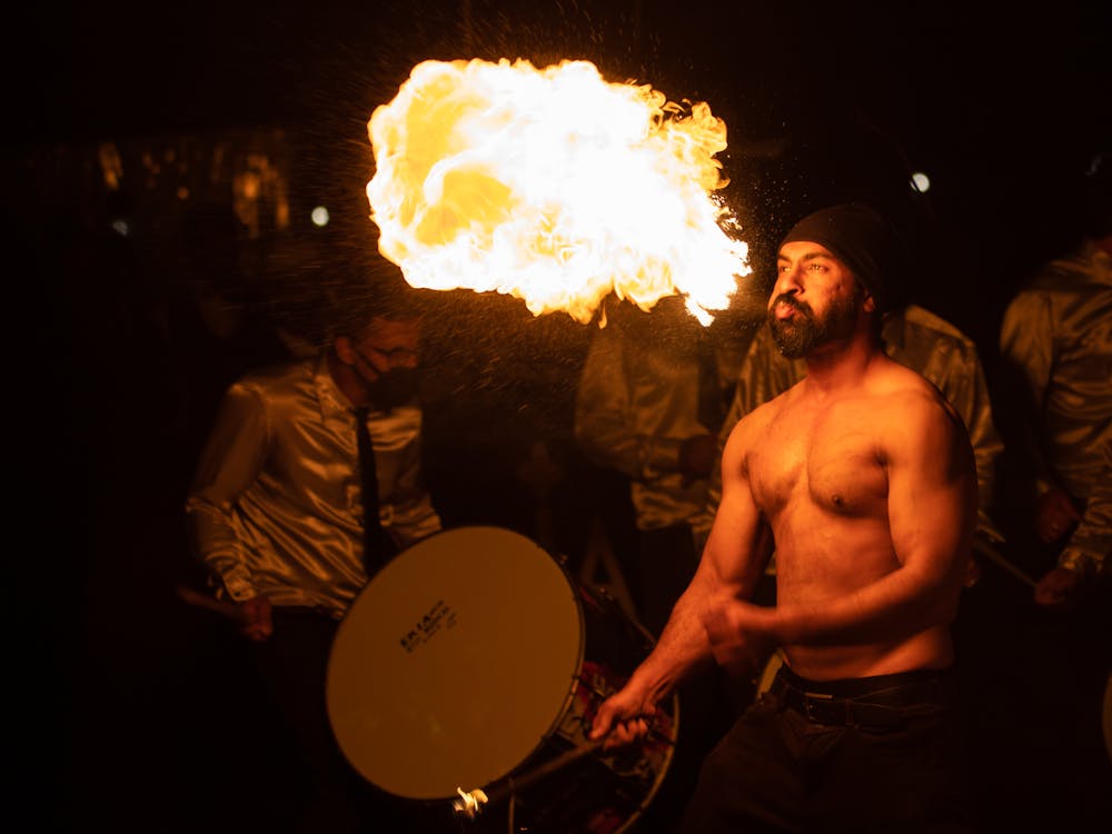 A Topless Man Blowing Fire