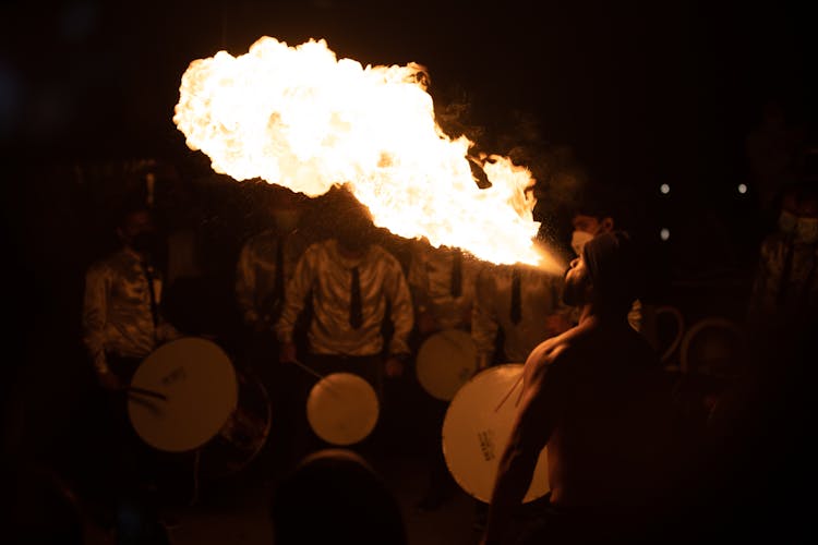 A Man Blowing Fire In A Festival