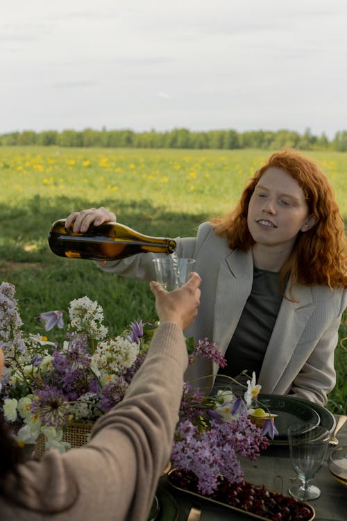 Red Haired Man in Beige Blazer Pouring Champagne at a Picnic