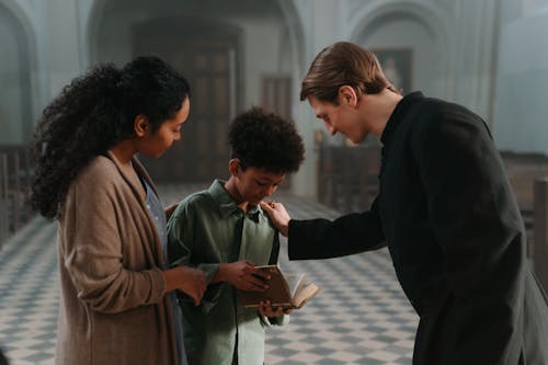 A Boy in Green Long Sleeve Holding a Bible