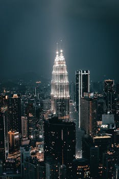 A breathtaking night view of Kuala Lumpur's skyline showcasing the illuminated Petronas Twin Towers.