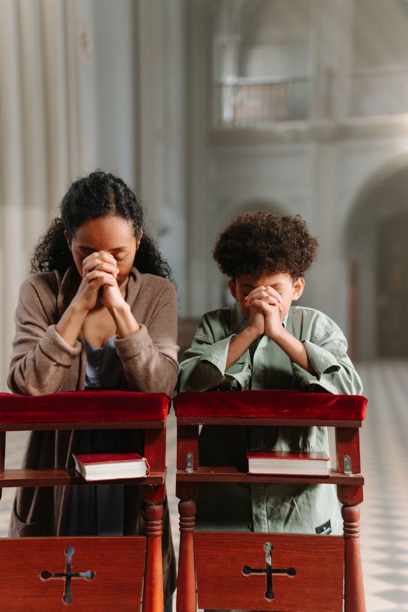 Mother and daughter praying together in church