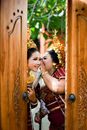 Woman in Red and Brown Dress Holding Brown Wooden Door