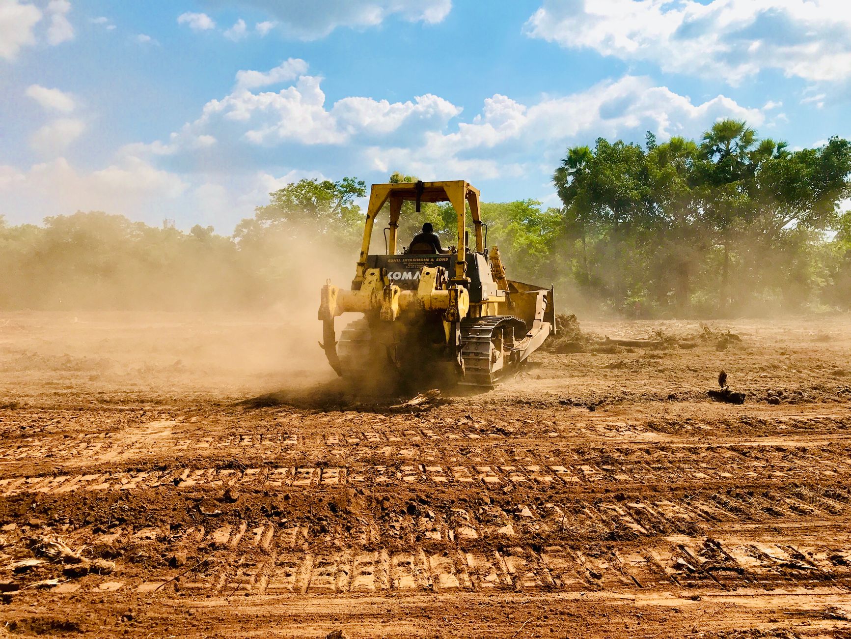 Dirt track maintenance tractors smoothing a muddy American racetrack before racing