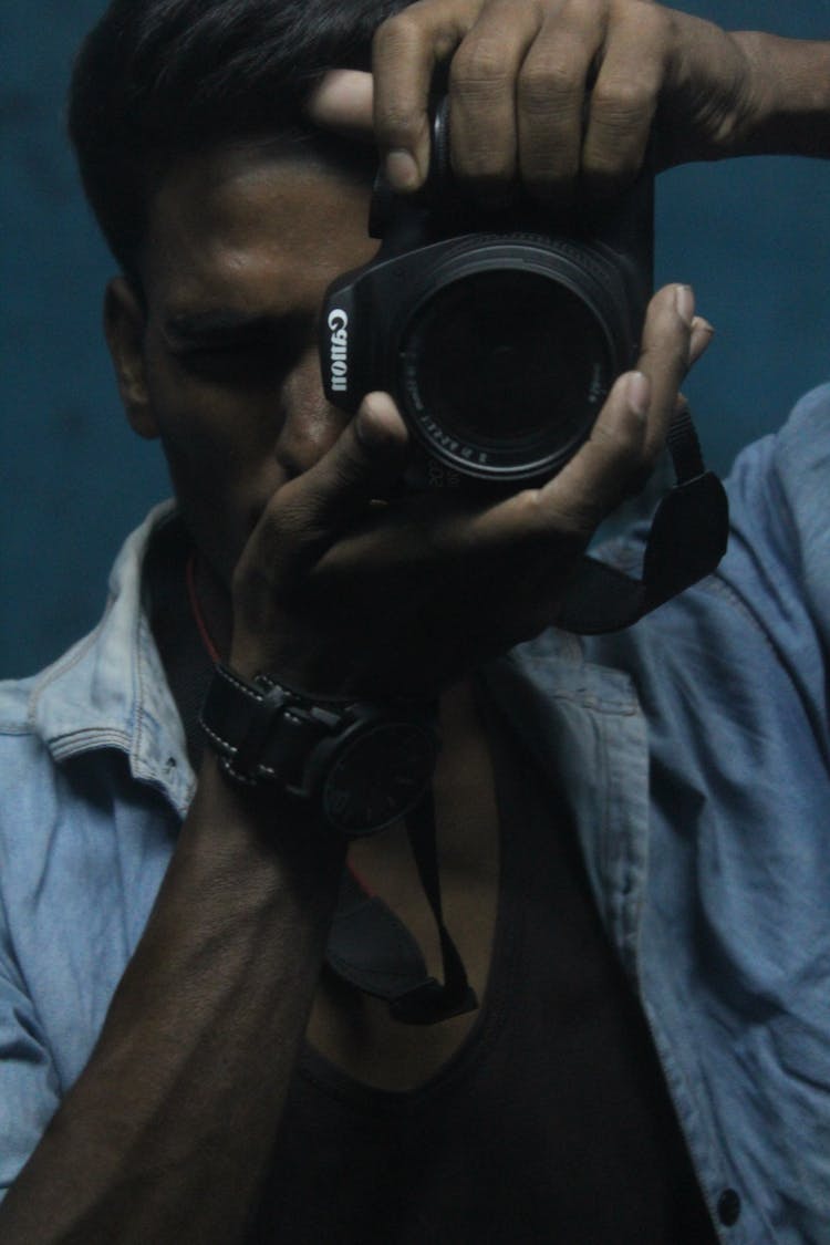 Man Holding Black Dslr Camera