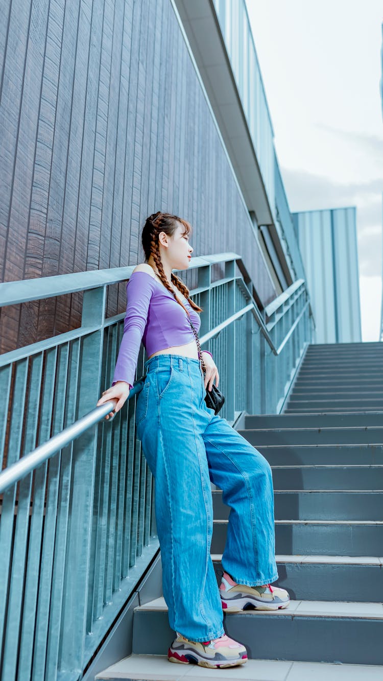 Woman In Bell Bottom Jeans Standing On Stairs