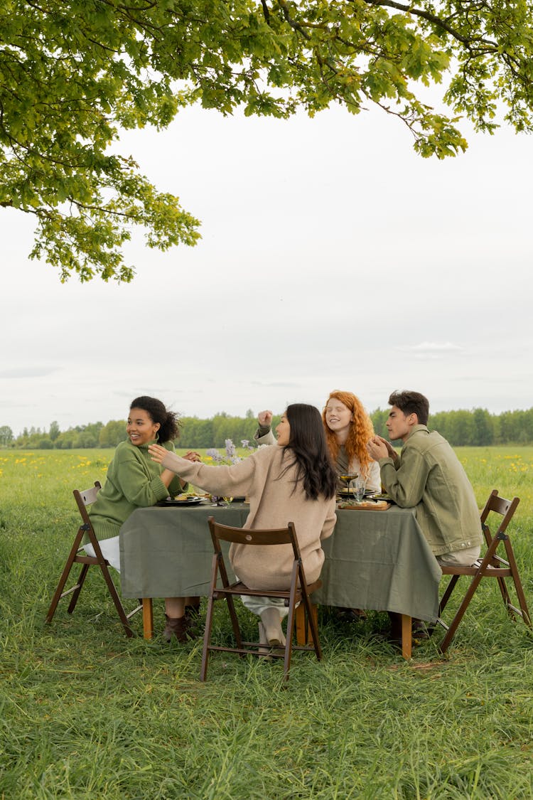 Group Of Friends Sitting On A Table Outdoors