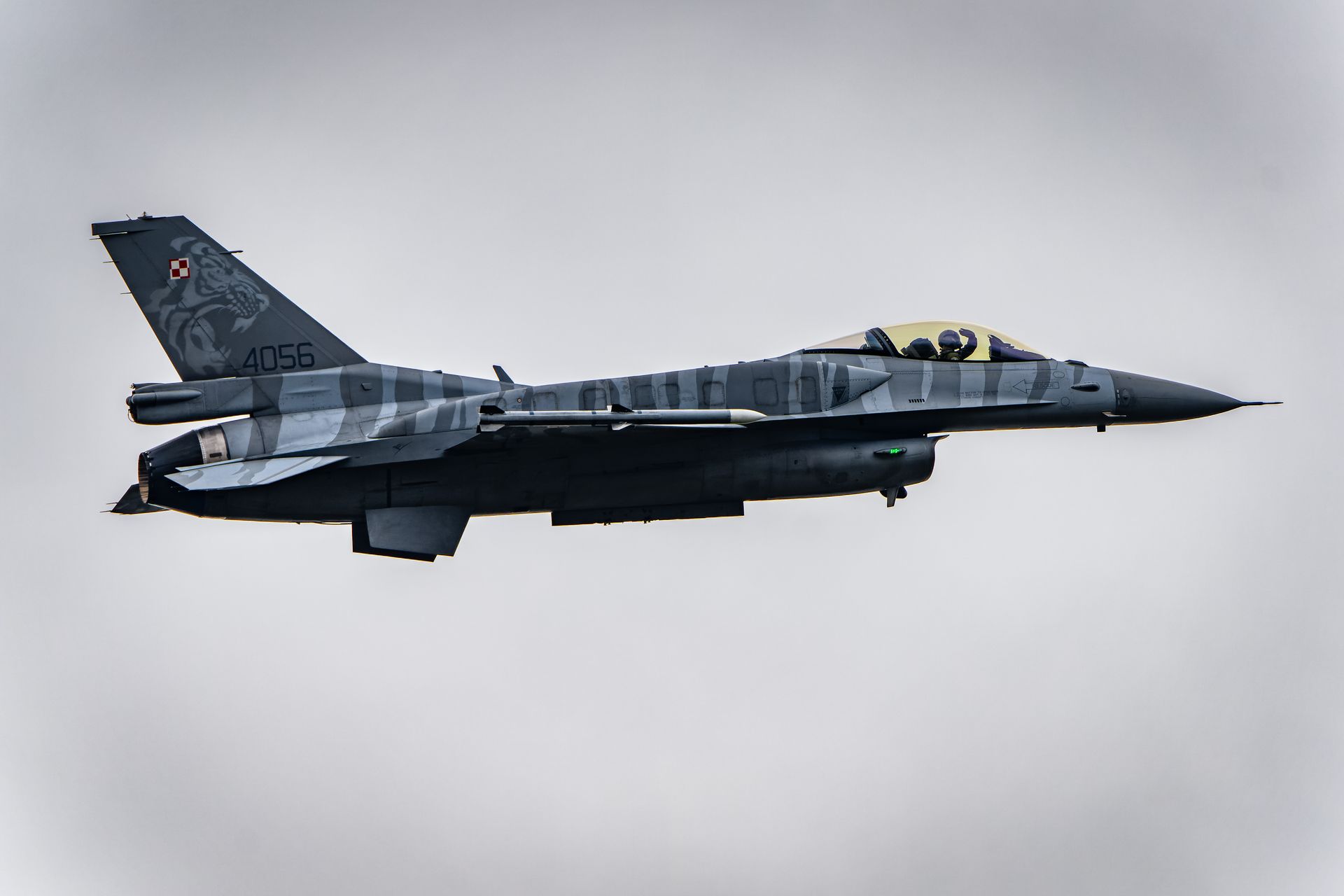 A powerful fighter jet soaring through the cloudy skies, showcasing military strength and aviation excellence.