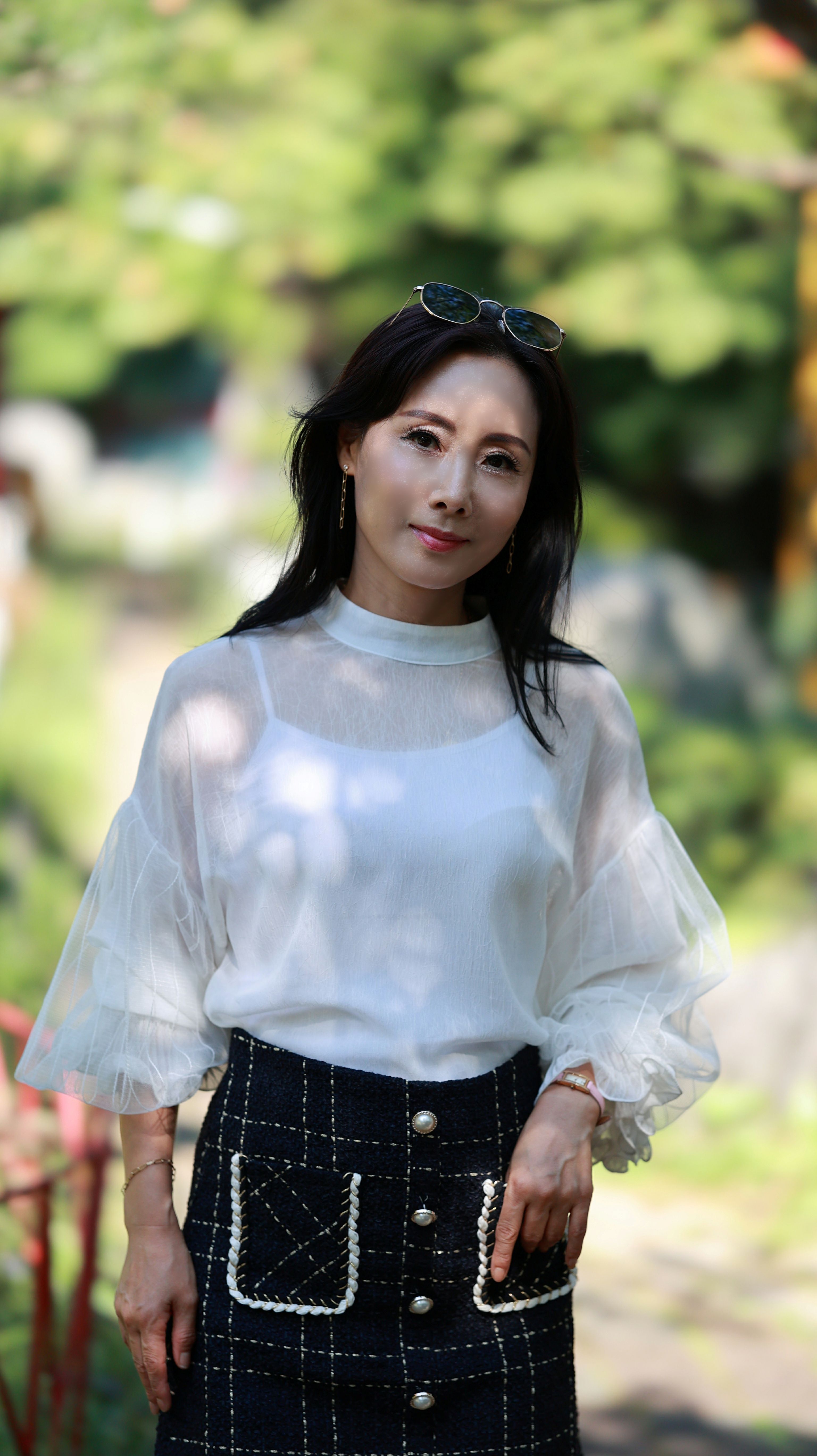 Elegant portrait of a fashionable woman outdoors, showcasing style and confidence.