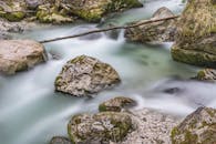 在宁静的森林里，长满青苔的岩石上流水平静，这是长时间曝光拍摄的效果