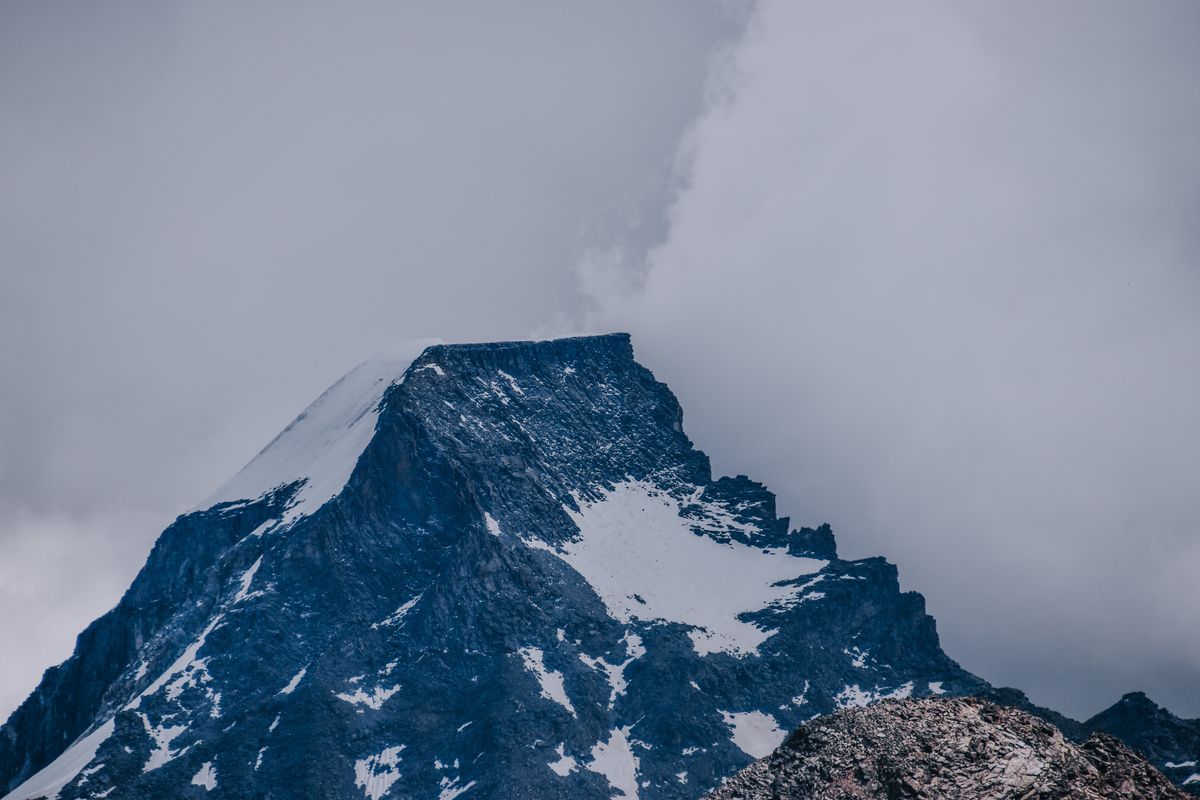 Snow-capped peak emerging from cloud — photo by Diana on Pexels