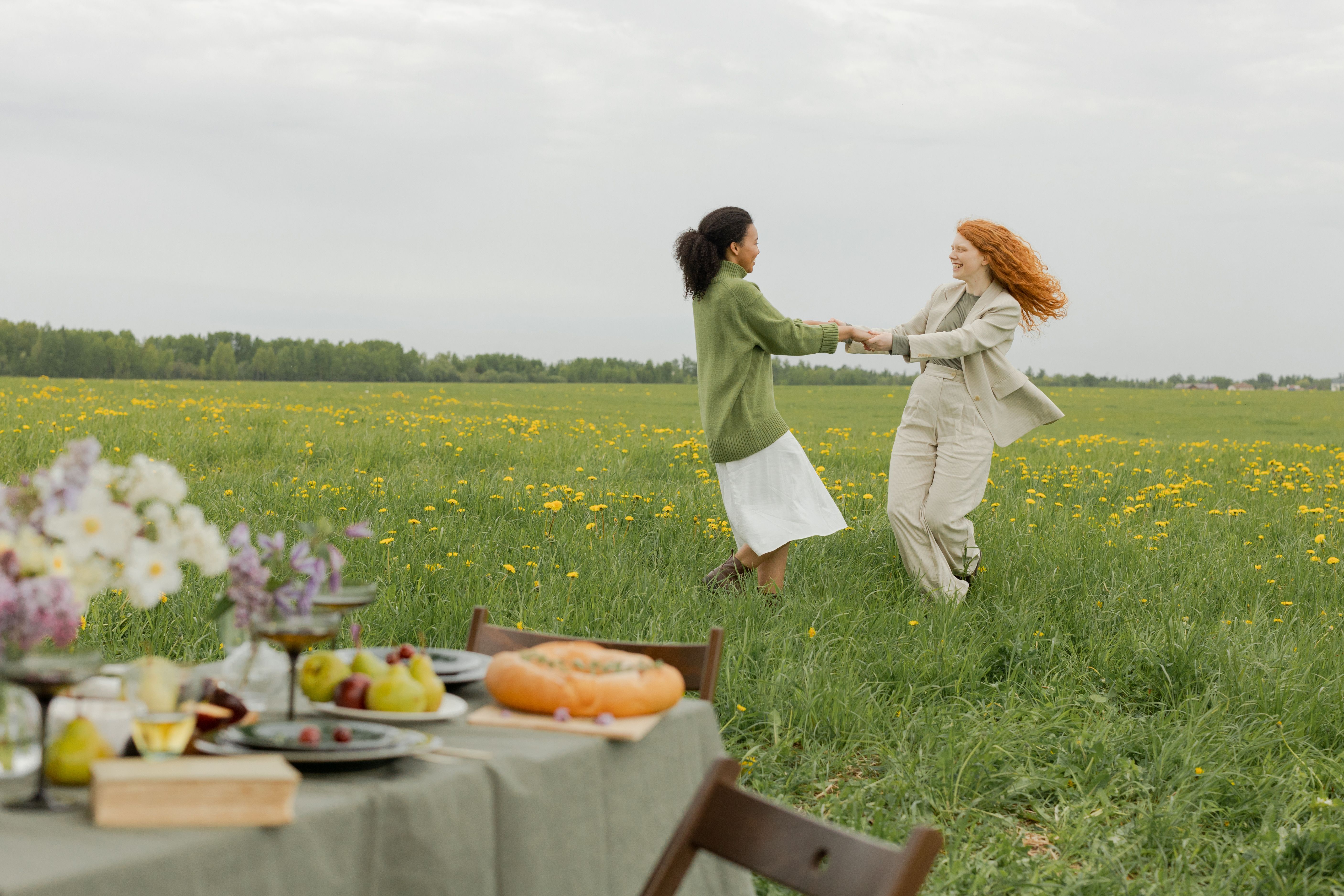 Women Holding Hands while in a Flower Field · Free Stock Photo